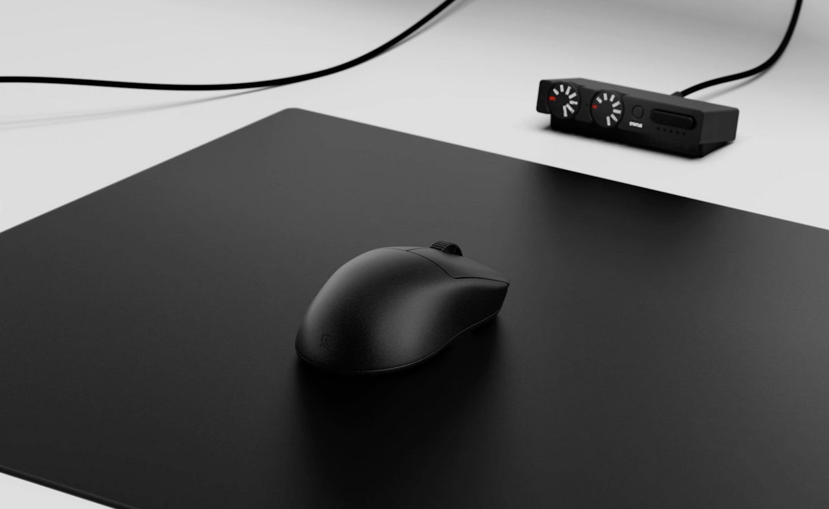 M-001 mouse on a black mousepad with its receiver on the desk