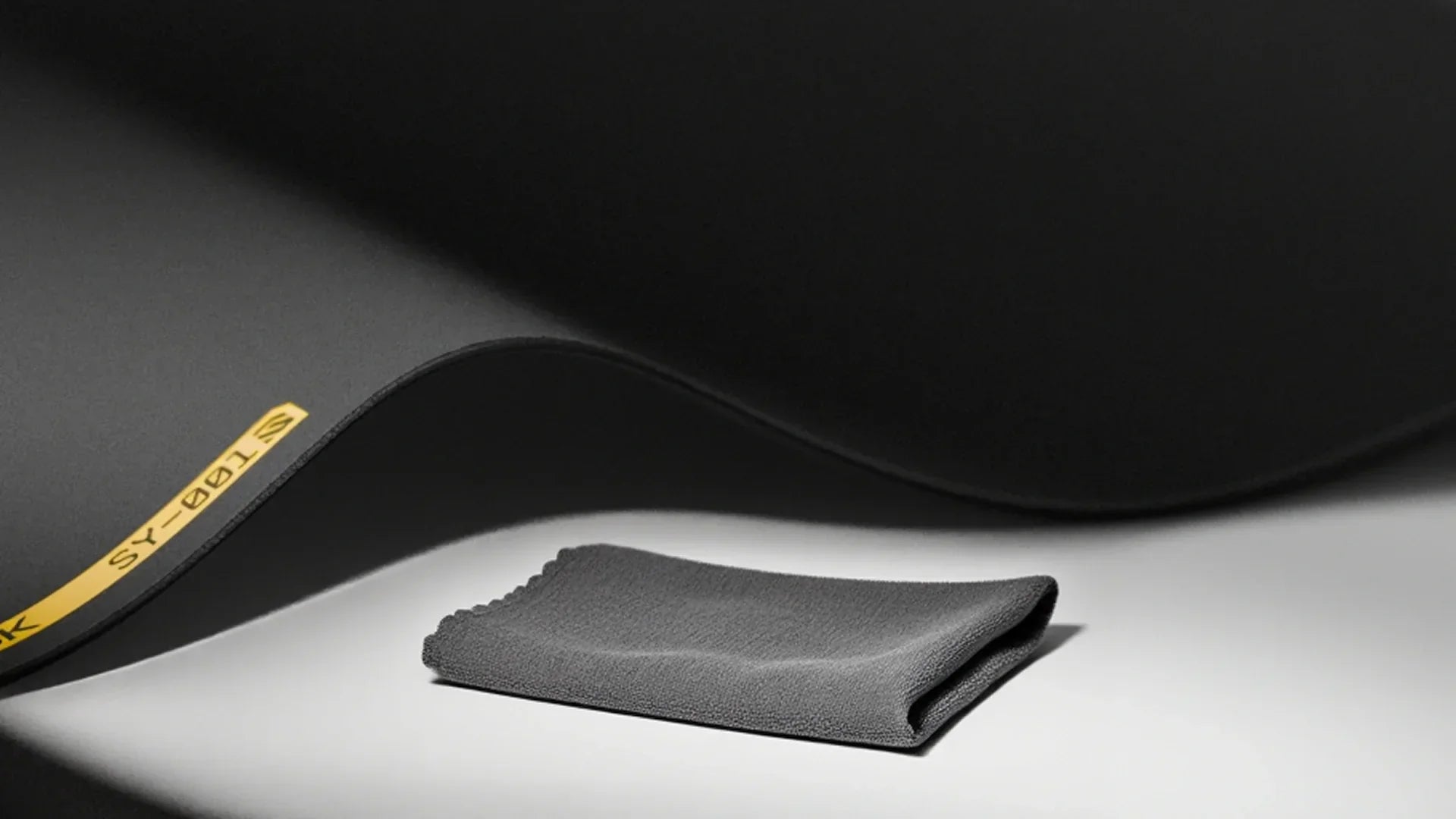 A cloth next to a mousepad that is being laid out to dry. 