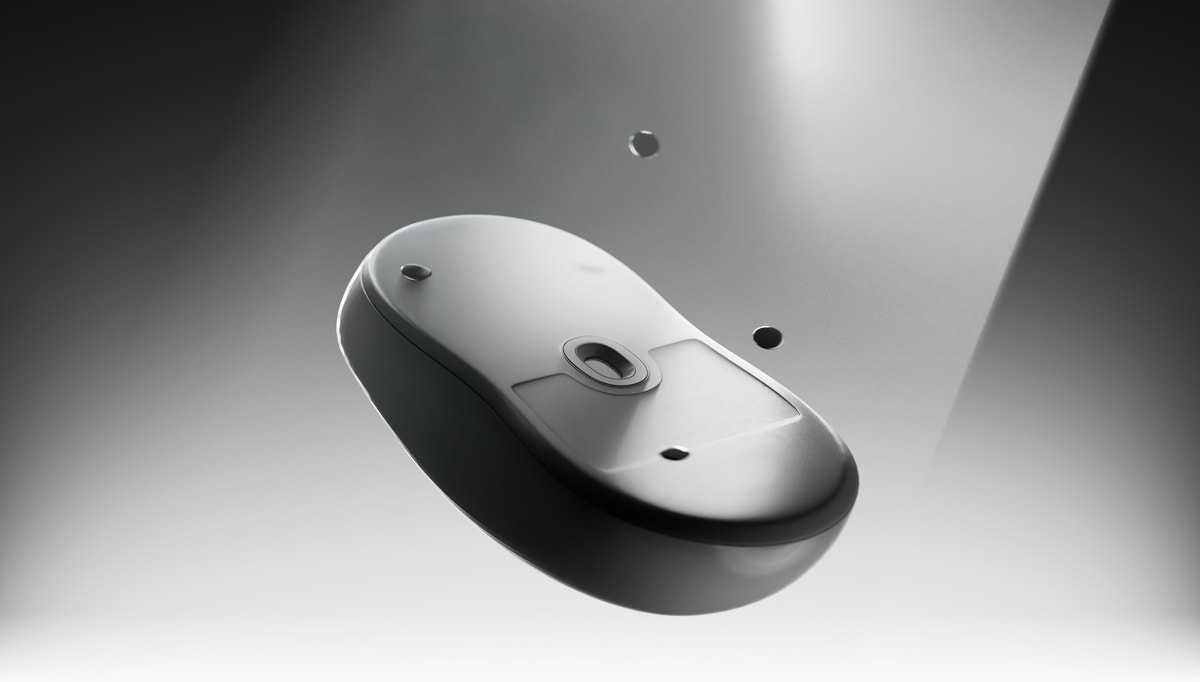 A gaming mouse with WALLHACK skates fitted, lit from above